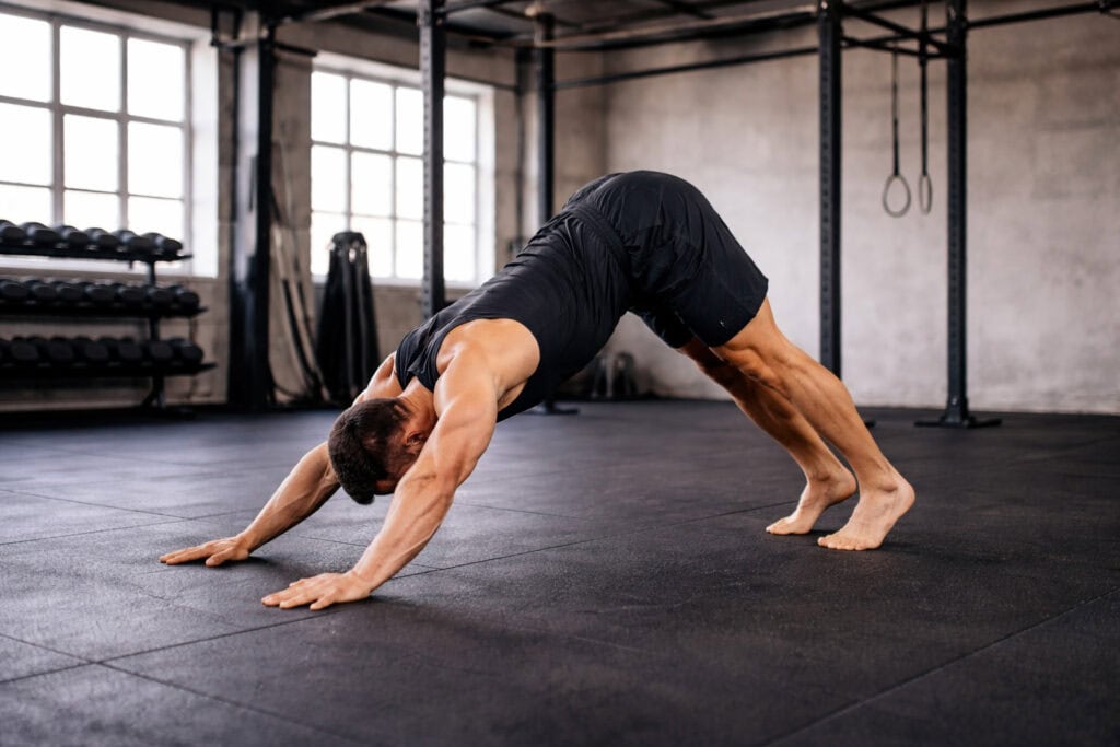 Plank-to-downward-dog-yoga-transition-on-gym-floor