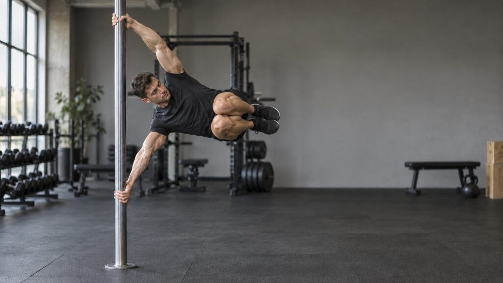 Tuck-human-flag-hold-with-knees-pulled-toward-the-chest