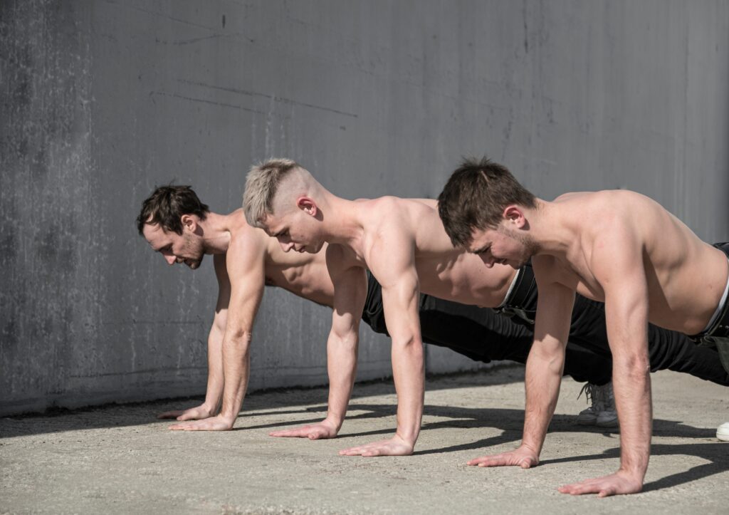 Three-men-standing-shirtless-outdoors-showing-lean-ectomorph-physique