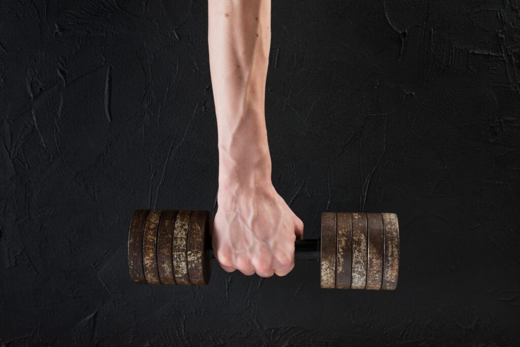 Close-up-of-a-man-holding-a-dumbell-focusing-on-grip-strength