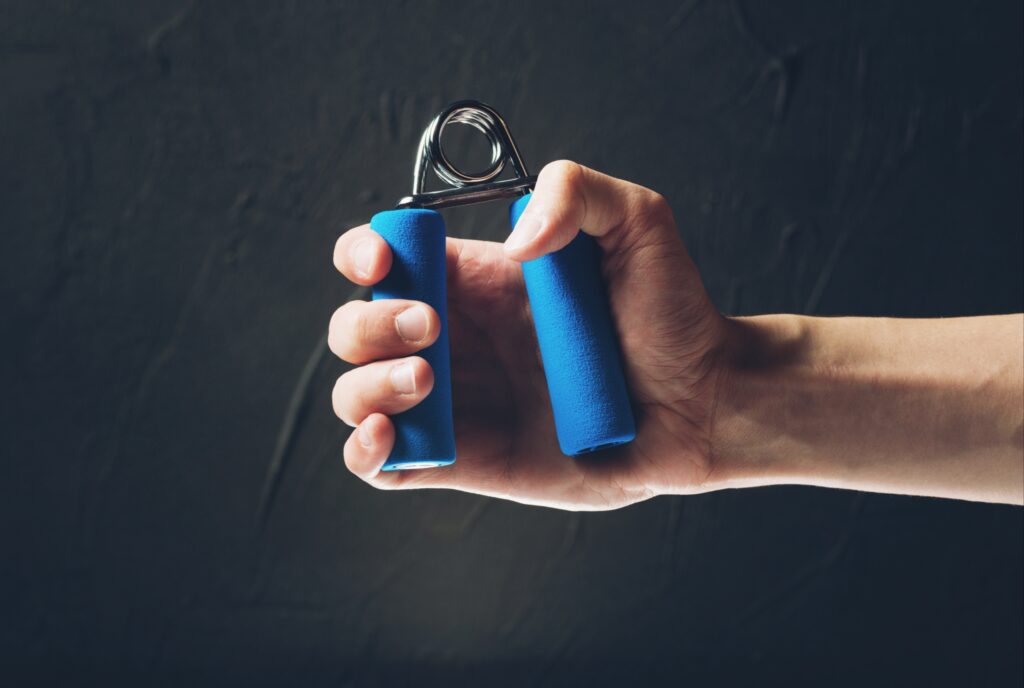 Close-up-of-a-hand-using-a-blue-hand-grip-trainer-for-strength-training