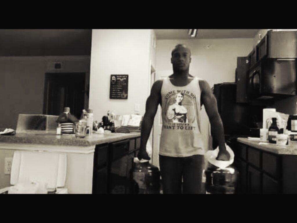 Man-performing-jug-carries-in-kitchen-for-strength-and-grip-training