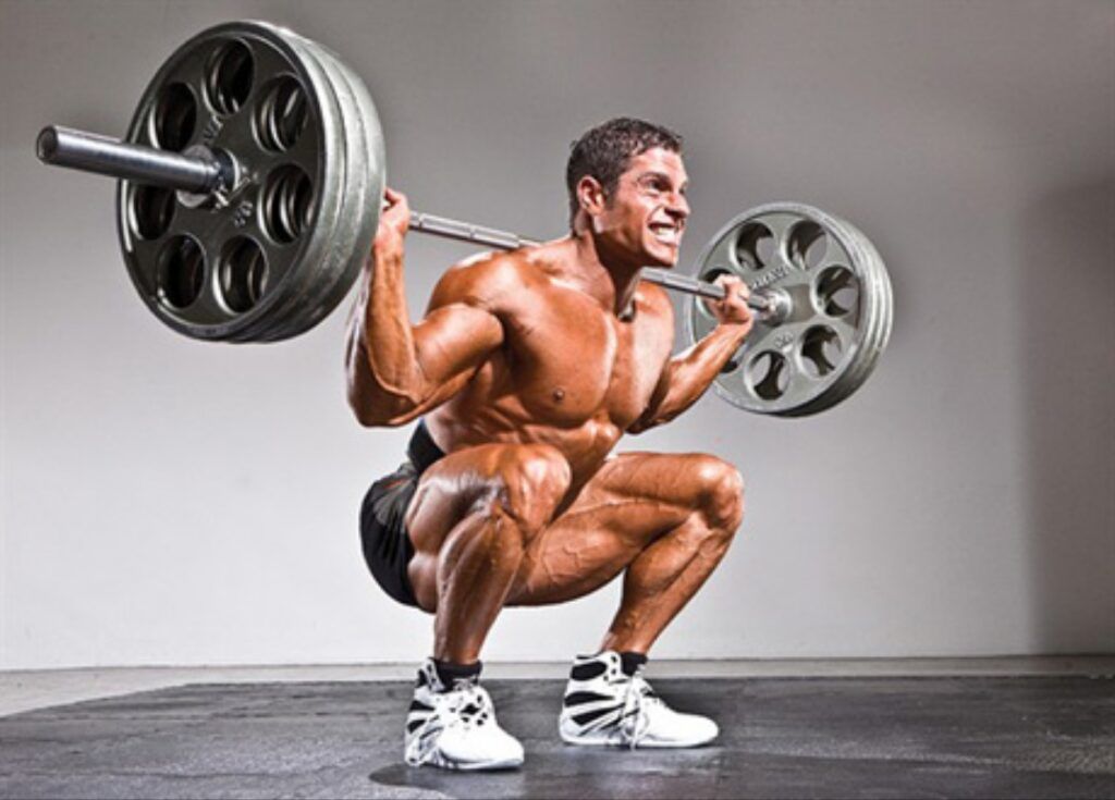 Shirtless-man-performing-a-deep-back-squat-with-a-barbell-in-a-gym