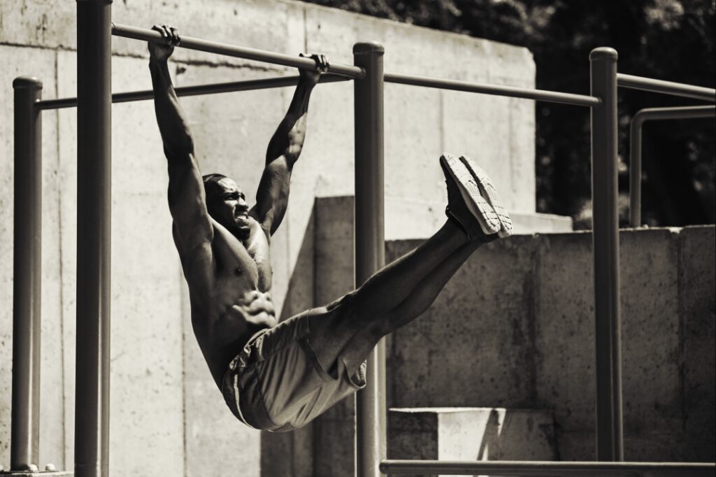 Man-performing-hanging-leg-raises-on-the-bars-outdoor-workout