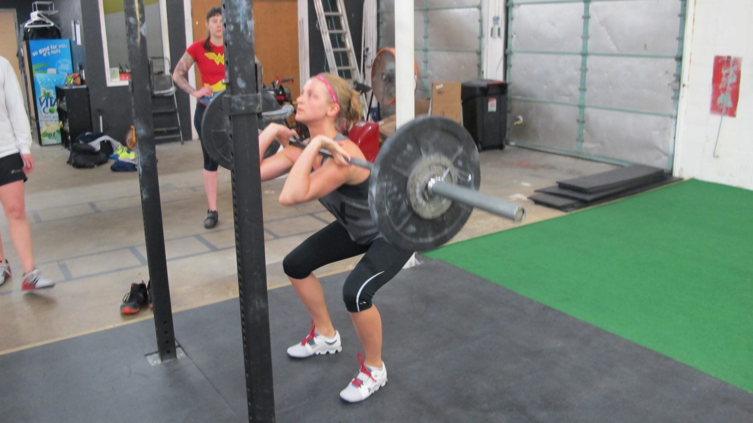 Woman-performing-front-squat-with-barbell-in-industrial-gym