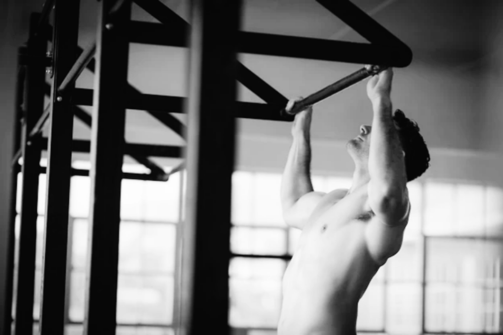 Man-performing-pull-up-on-gym-bar-indoor-workout