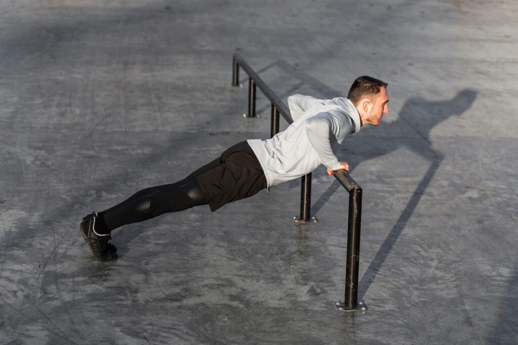 Man-performing-push-up-on-bar-functional-fitness-outdoors