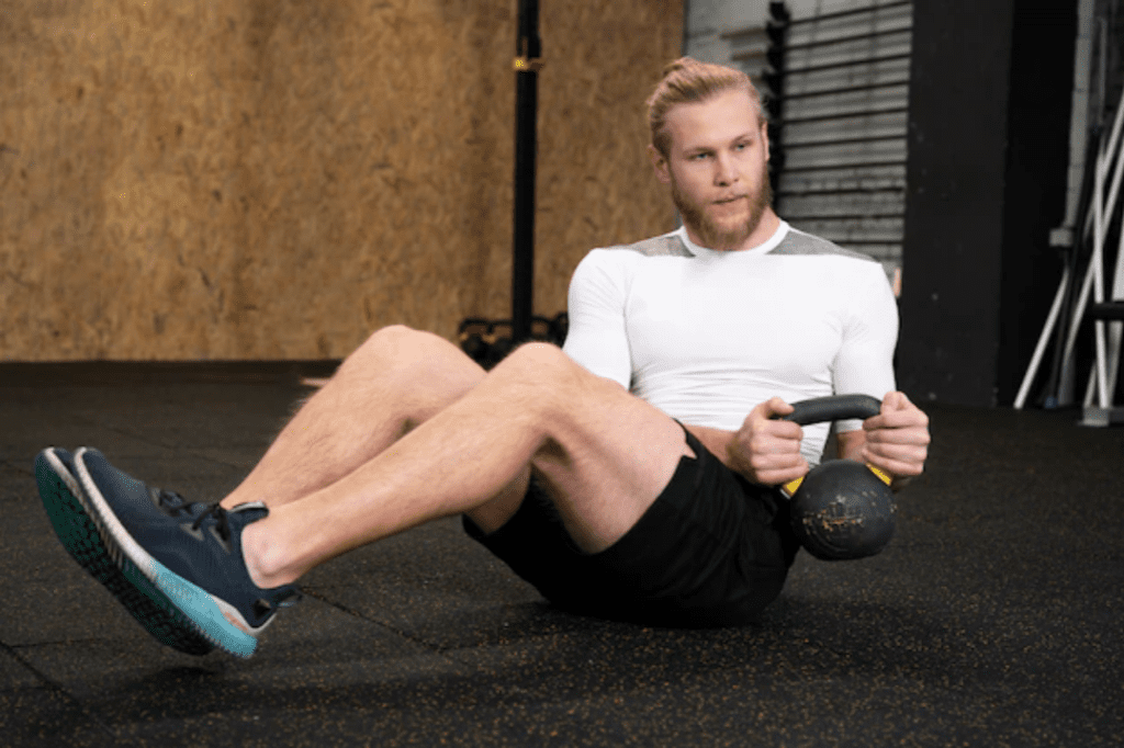 Man-performing-weighted-russian-twists-with-kettlebell-gym-workout
