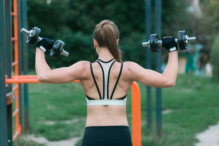 Back-view-of-woman-training-shoulders-with-dumbbells
