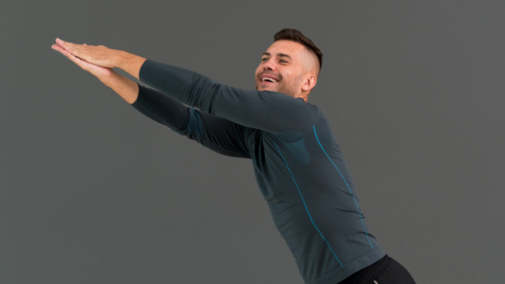 Man-doing-forward-arm-stretch-in-sportswear
