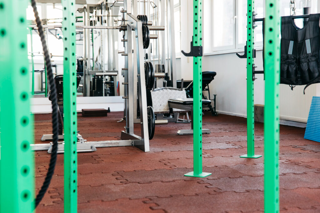 Green-squat-rack-in-modern-gym-with-weight-plates-and-strength-training-equipment